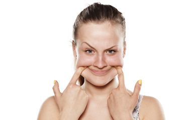 angry woman pulls out her mouth with her fingers to smile