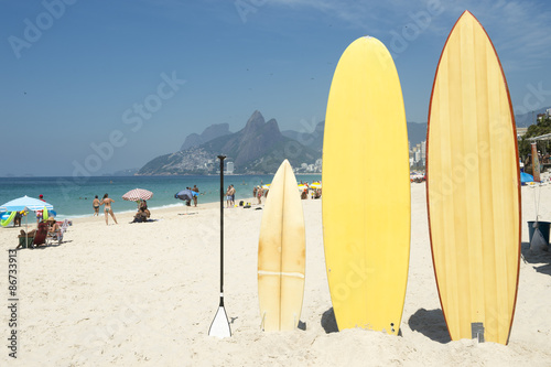 Fototapeta na szkło Deski surfingowe i deski wiosłowe ustawiają się na plaży w Arpoador, Ipanema, Rio de Janeiro, Brazylia