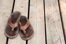 Pair Of Well Worn Sandals On A Wooden Dock