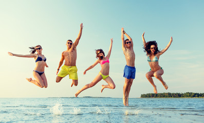 Wall Mural - smiling friends in sunglasses on summer beach