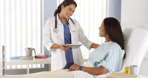 Fotomural Hispanic female doctor talking to African patient