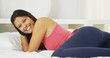 Young mixed race woman lying on bed smiling