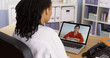 Female patient talking to African American doctor over video chat