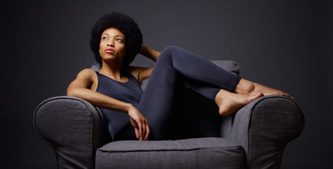 Black woman sitting in chair thinking