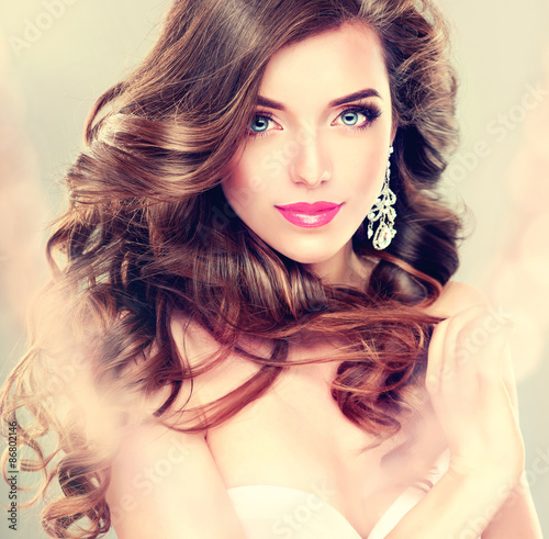 Leinwand Poster Beautiful model brunette with long curled hair and jewelry earrings