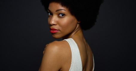 African woman wearing white gown looking over shoulder