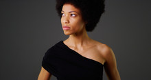 African Woman In Stylish Black Dress On Grey Background