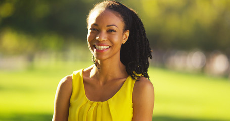 Wall Mural - Happy black woman smiling in a park