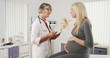 © rocketclips - Happy pregnant woman talking with doctor