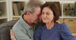 © Mark Adams - Loving senior couple cuddling on couch