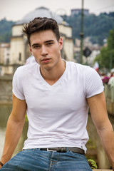 Wall Mural - Handsome young man in white t-shirt outdoor in city