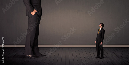 Fotografía Little bussinesman in front of a giant boss legs concept