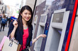 happy young chinese girl at the cash machine