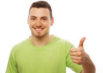 Wall Mural - young man in green shirt  showing thumbs up. 