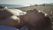 Handsome man laying topless on a beach relaxing