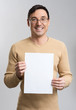 © spaxiax - Young man holding a blank sheet
