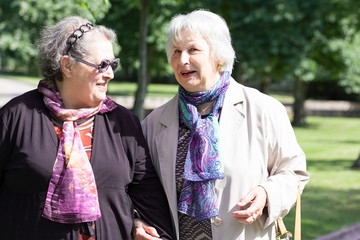 two mature ladies walking friendly to the park