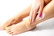 Depilacja nóg woskiem.
Kobieta depiluje nogi plastrem z woskiem