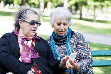 two mature ladies discovering technology with smart phone