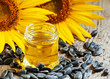 Sunflower oil in the pot, and sunflower seeds on an old wooden b