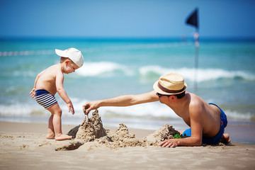 father and son build sand castle