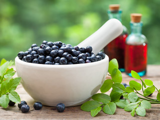 Wall Mural - Mortar with  blueberries and bottles of tincture or cosmetic pro