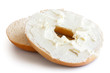 Plain bagel cut in half and spread with cream cheese. Isolated on white.