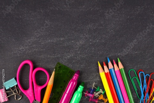 Fotografía útiles escolares borde inferior sobre un fondo de pizarra