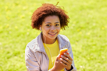 Canvas Print - happy african woman with smartphone and earphones