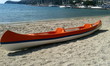 orange plastic sea kayak on beach with no one