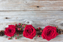 Horizontal Image Of An Old Rustic Wood Background With Three Bold Red Roses Connected With Cranberries And Twigs Along Bottom Of Image With Lots Of Empty Space For Text Great For A Greeting Card Idea