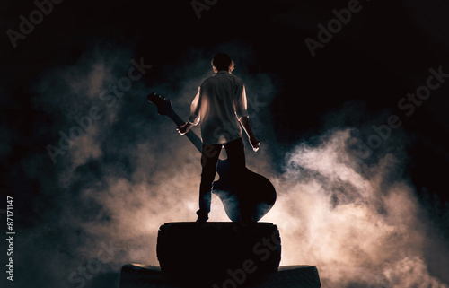 Valokuva Rock musician and large guitar, a lot of smoke