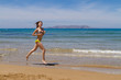 © Stockphototrends - Young busty brunette in swimwear jogging at the beach.