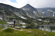Bulgarian Bagpiper Playing By A Mountain Lake