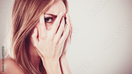 Fotomural Afraid frightened woman peeking through her fingers