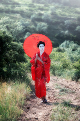 Wall Mural - Portrait of a woman in geisha makeup walking in the countryside