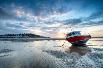 Wall Mural - Red fishing boat on the beach at Instow and looking out at Appledore across the water