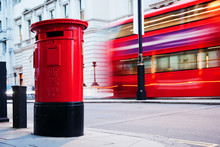Traditional Red Mail Letter Box And Red Bus In Motion In London, The UK.
