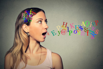 woman talking alphabet letters in her head coming out of open mouth