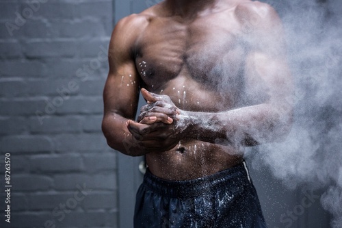Fotografie, Obraz Young Bodybuilder shaking Chalk off his hands