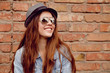 © elenakibrik - Happy beautiful woman stands near the old brick wall.