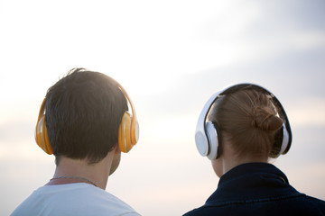 Young people in headphones enjoying music outdoor