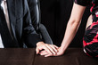 会社で怪しく手を握っている男女カップル