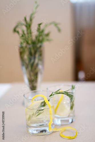 Fototapeta na drzwi i meble Two cocktail glasses and rosemary branches on a table