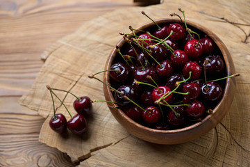 Wall Mural - Sweet cherries in a bowl on a wooden background, studio shot