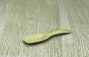 Empty wooden spoon on a wooden background