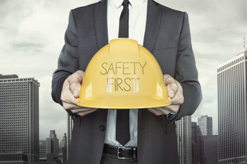 Safety first text on helmet what businessman is holding