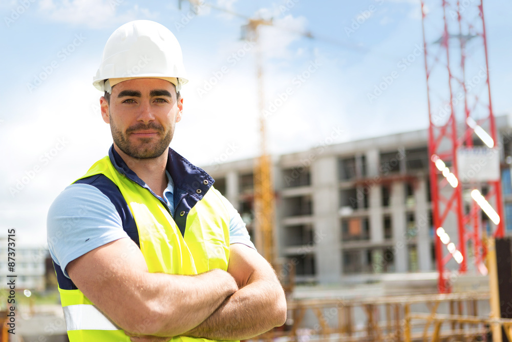 Portrait of an attractive worker on a construction site - obrazy, fototapety, plakaty 