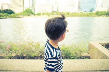 Little boy walking though the lagoon in the park