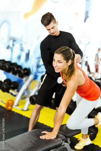 Photo Young male trainer giving instructions to a woman in a gym
